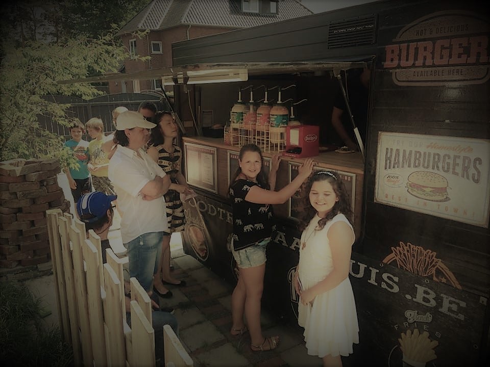 Communicantje en gasten aan de foodtruck op een communiefeest