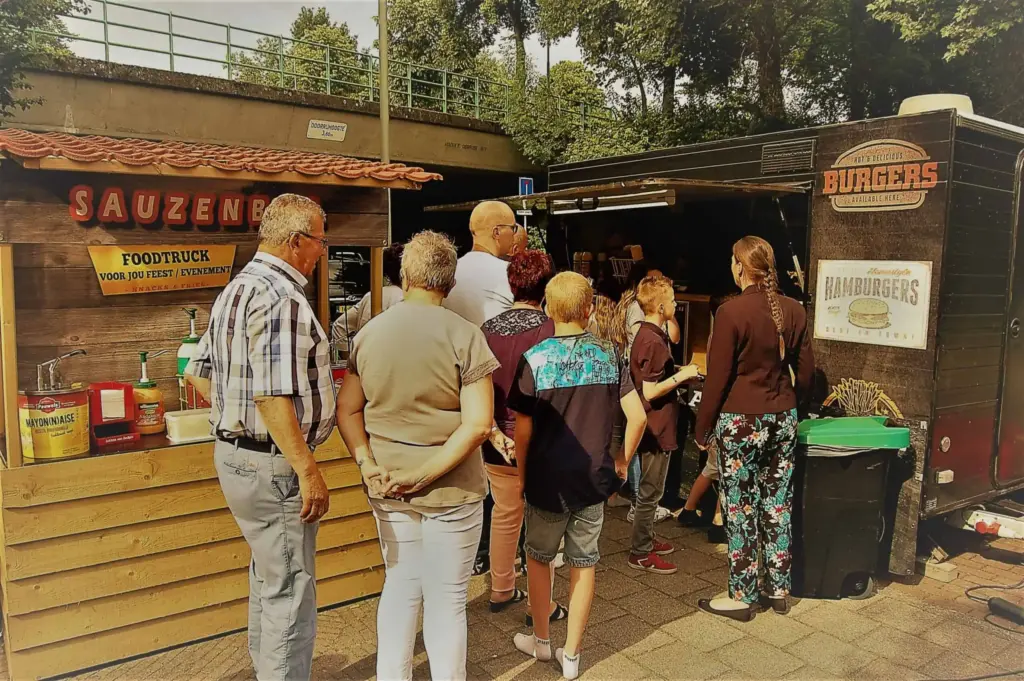 Gasten aan de foodtruck tijdens een feest
