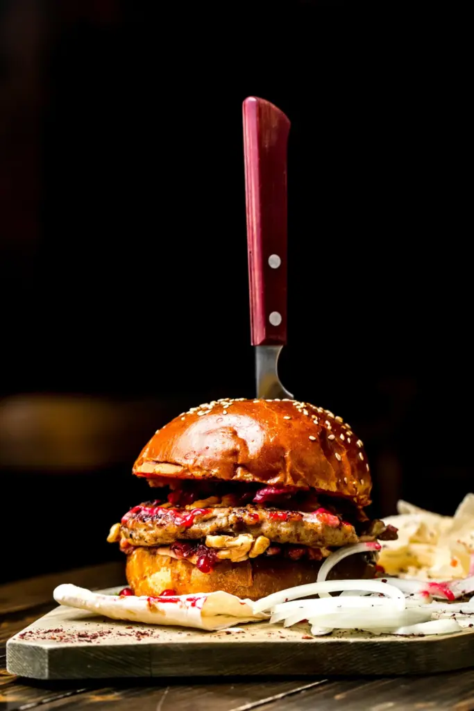 Gourmet burger met prikker op een houten plank